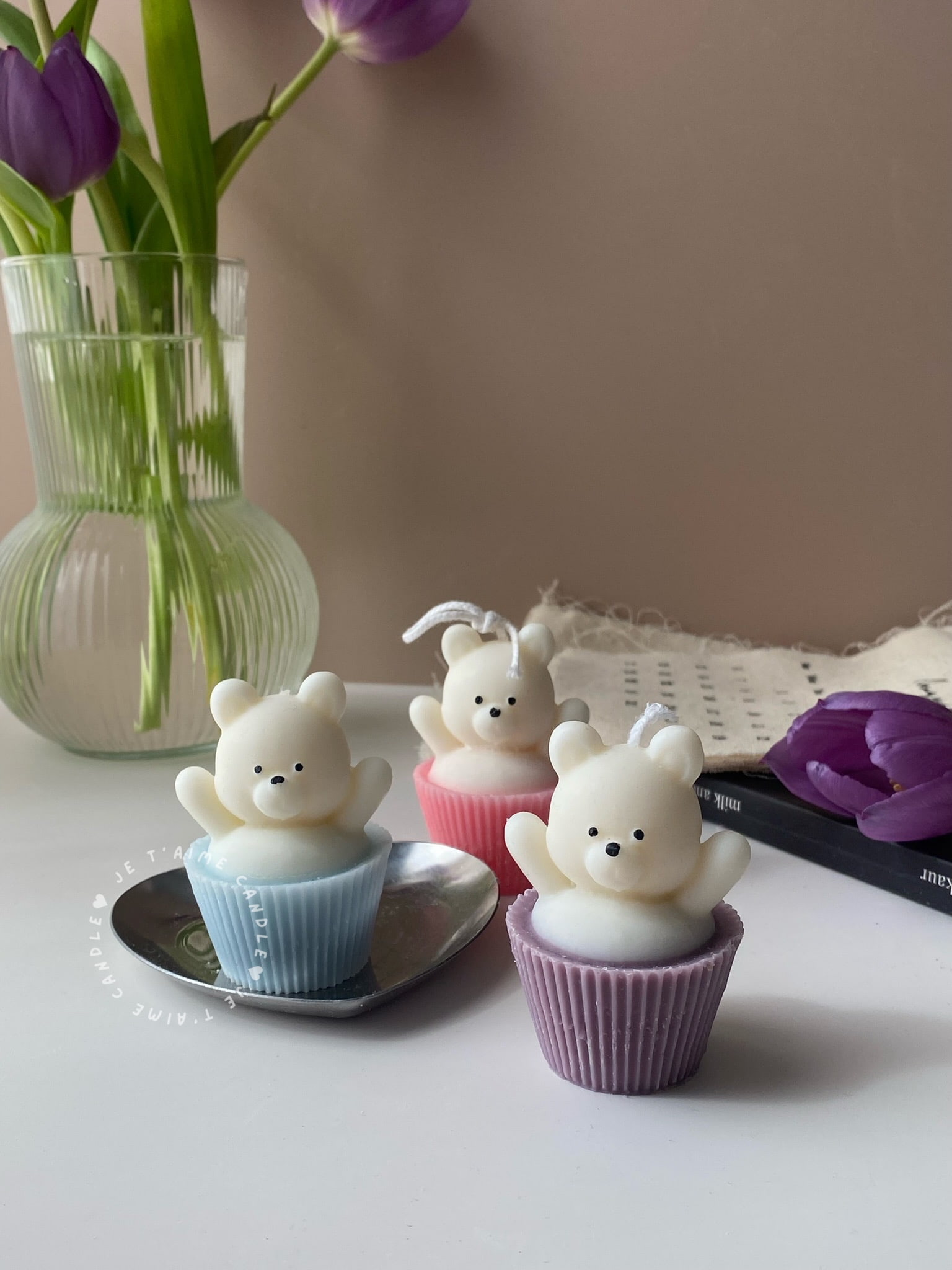 Set of handcrafted Muffin Teddy Bear Candles made from natural soy wax, designed in pastel cupcake holders in pink, purple, and brown. Cute decorative bear-shaped candles ideal for home décor, nursery styling, birthday gifts, anniversaries, baby showers, or special occasions. Handmade in the UK, these kawaii aesthetic candles add a cozy, unique, and charming touch to any space.