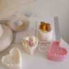 Two small cream white cakes topped with cute baby bear decorations and a colorful birthday candle.