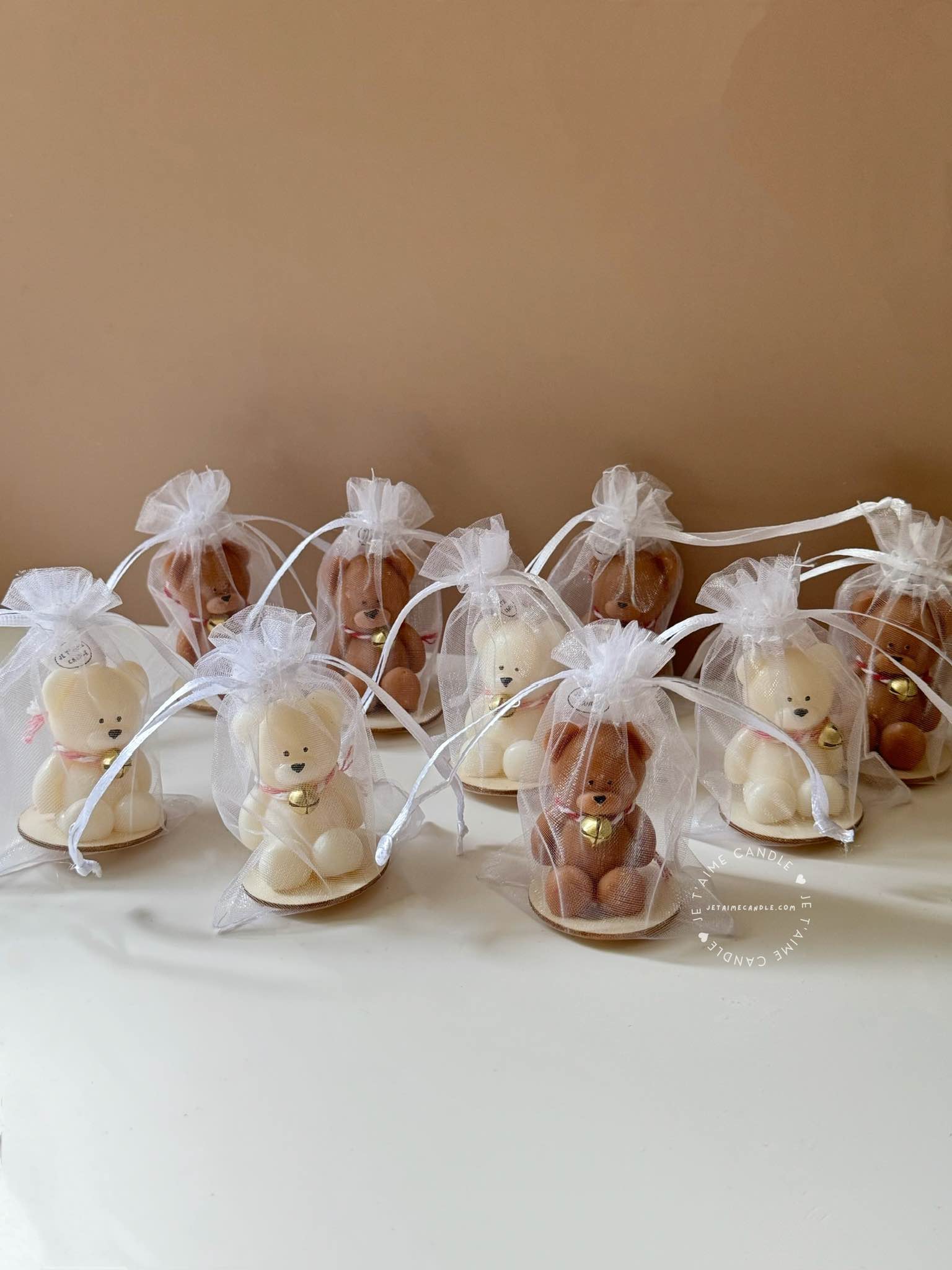 Handmade Mini Bear Candle with Bell Charm in Organza Bag on Rustic Wood Slice – an adorable, heartwarming candle gift for special occasions like baby showers, gender reveals, birthdays, and festive gatherings. This charming favor spreads joy and warmth, adding a touch of sweetness to celebrations and lighting up memorable moments with its delightful glow.