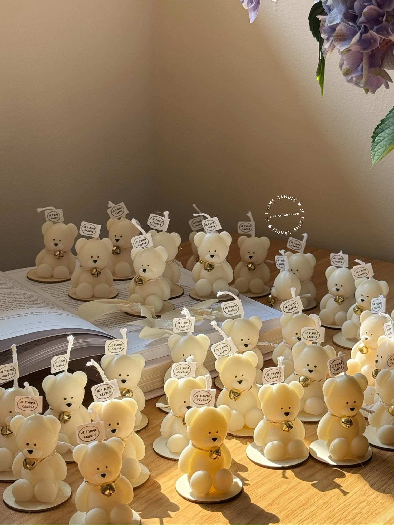 Handmade Mini Bear Candle with Bell Charm in Organza Bag on Rustic Wood Slice – an adorable bear-shaped candle with a bell charm, elegantly presented in an organza bag atop a wood slice. Perfect for baby showers, gender reveals, birthdays, or festive gatherings, adding warmth, charm, and joy to special occasions and party favors.