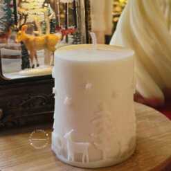 A handcrafted Christmas pillar candle featuring a beautiful deer scene, adding a touch of winter magic to your home. This elegant candle is perfect for holiday decor or as a unique gift, bringing warmth and seasonal charm to any room.