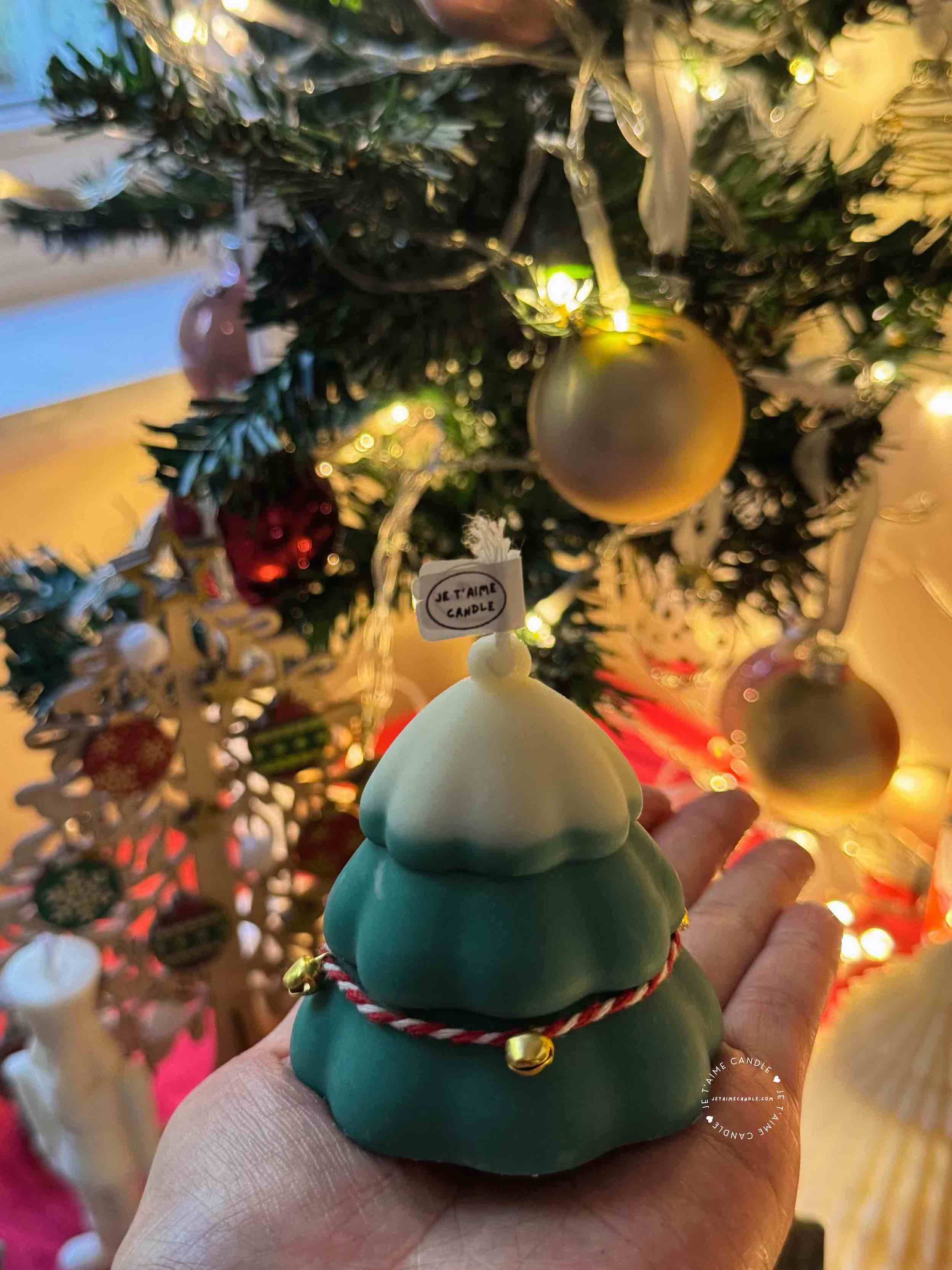 Handcrafted Christmas tree candle made from high-quality soy wax, decorated with a twine bow and small jingle bells. Perfect for holiday decor or as a gift, this festive candle adds charm to any space.
