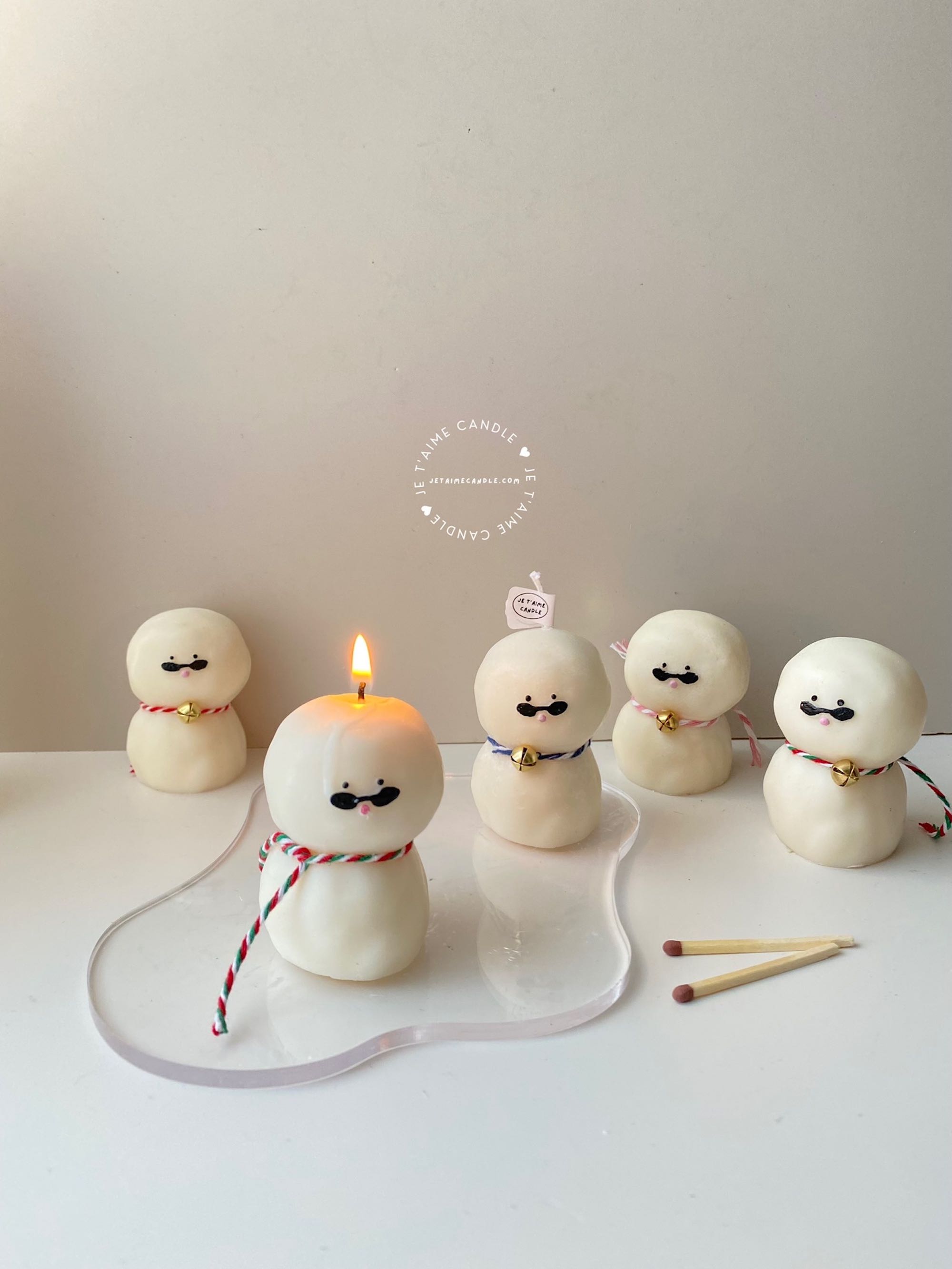 An adorable handmade snowman candles, perfect for Christmas decor or holiday gifts. Each candle features a snowman with a cute sunglasses and a holiday bell, crafted from high-quality wax for a clean burn. The charming design adds warmth and festive cheer to any room, ideal for winter themes or cozy home decor.