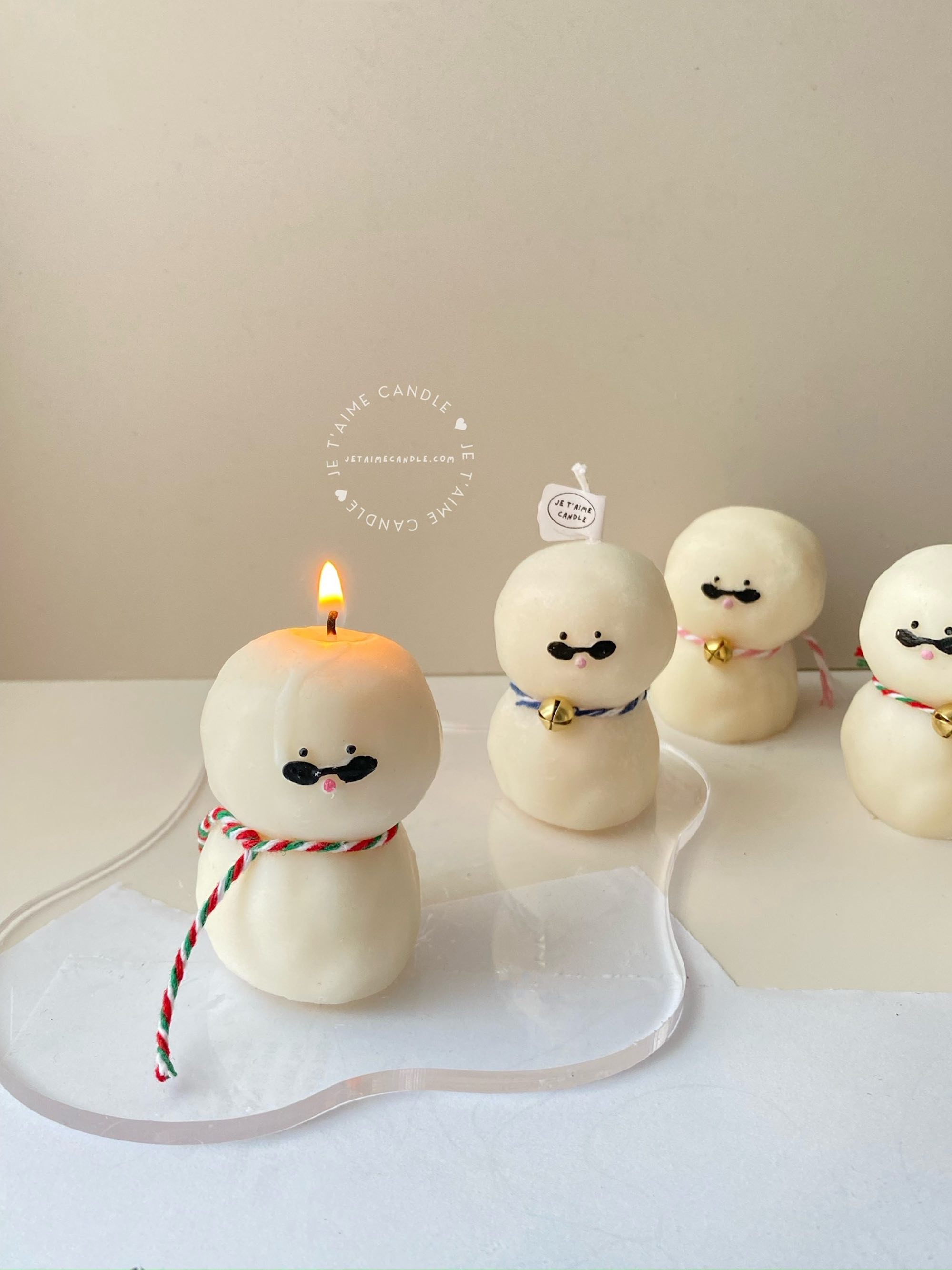 An adorable handmade snowman candles, perfect for Christmas decor or holiday gifts. Each candle features a snowman with a cute sunglasses and a holiday bell, crafted from high-quality wax for a clean burn. The charming design adds warmth and festive cheer to any room, ideal for winter themes or cozy home decor.