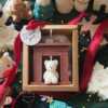 A cozy box featuring a teddy bear surrounded by festive Christmas decorations, perfect for holiday warmth and charm.