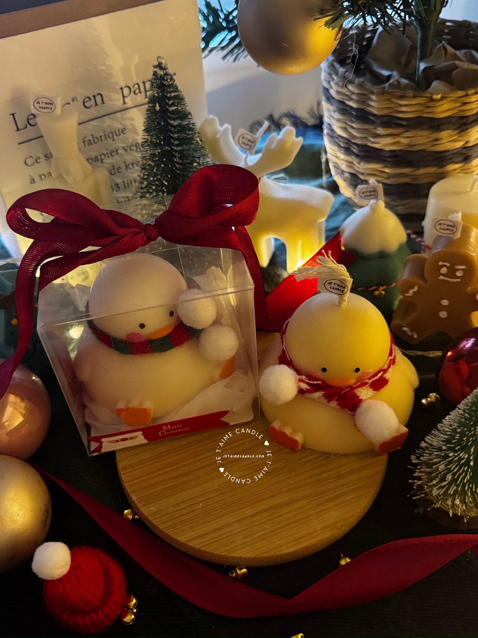 Two ducks in candle cozy scarves resting on a wooden board, ideal for unique holiday decor and gift inspiration.