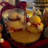Two ducks in candle cozy scarves resting on a wooden board, ideal for unique holiday decor and gift inspiration.