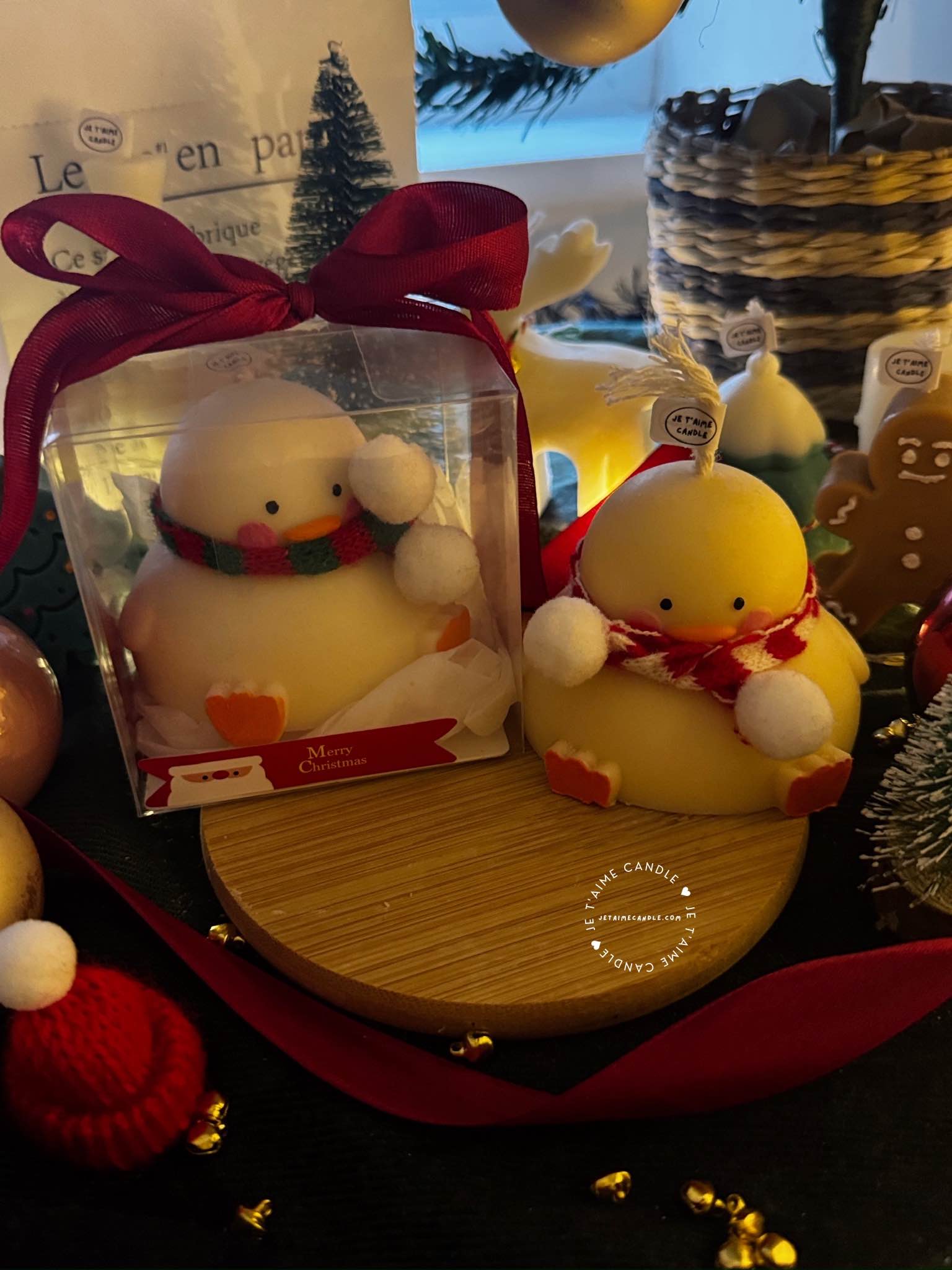 Two ducks in candle cozy scarves resting on a wooden board, ideal for unique holiday decor and gift inspiration.