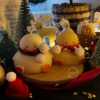Two ducks in candle cozy scarves resting on a wooden board, ideal for unique holiday decor and gift inspiration.