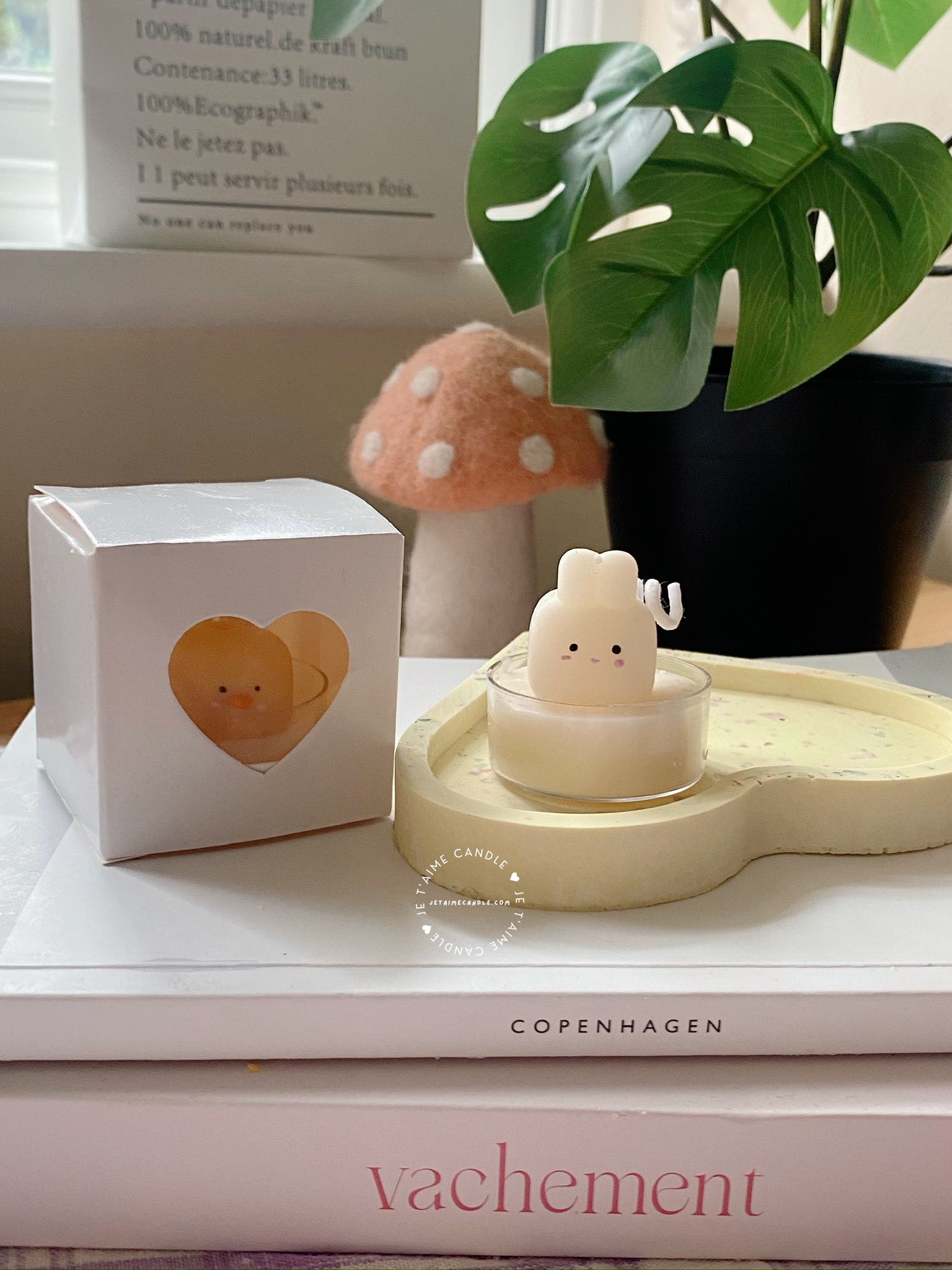 A table displaying unique animal-shaped candles and a book, perfect for enhancing the charm and coziness of any space.