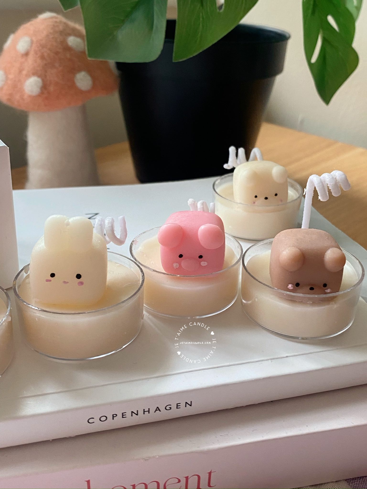 A table displaying unique animal-shaped candles and a book, perfect for enhancing the charm and coziness of any space.