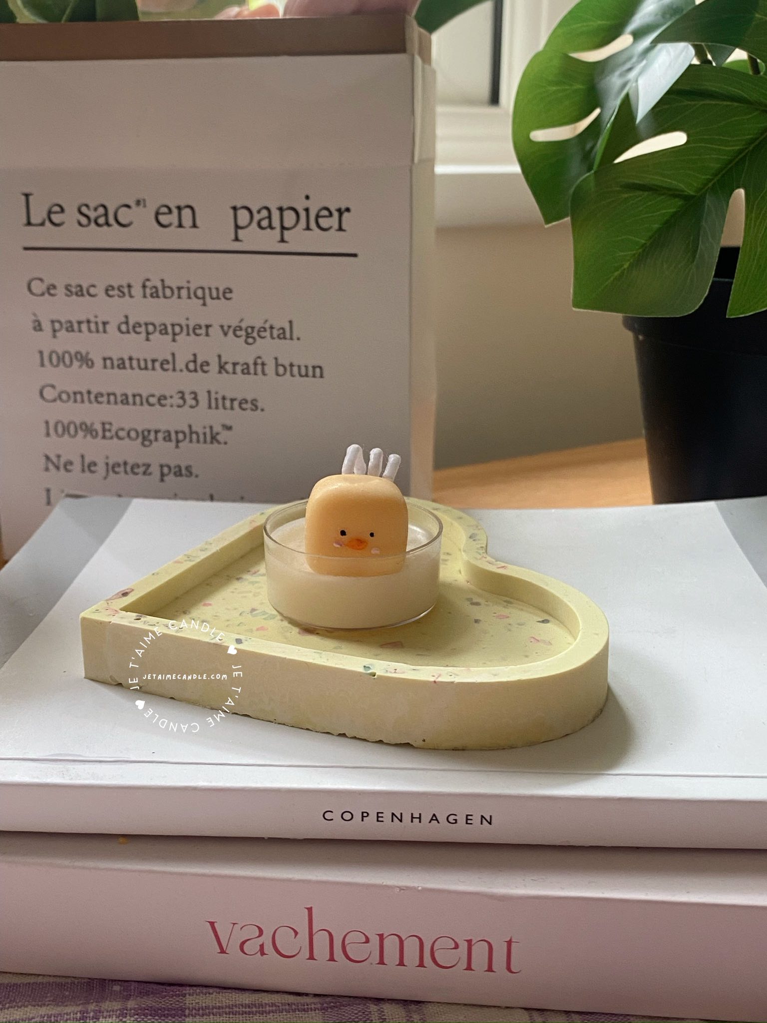 A table displaying unique animal-shaped candles and a book, perfect for enhancing the charm and coziness of any space.