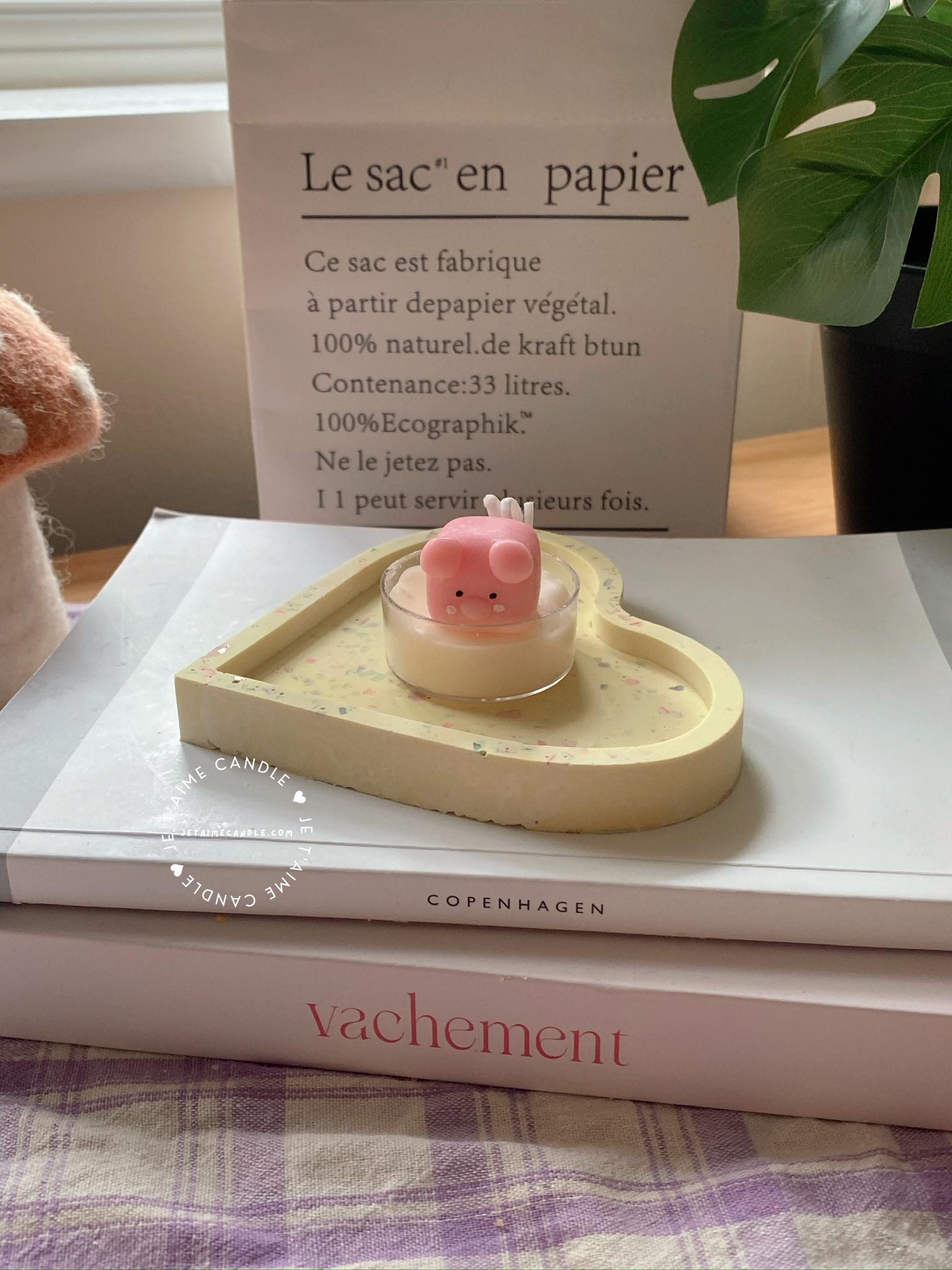 A table displaying unique animal-shaped candles and a book, perfect for enhancing the charm and coziness of any space.