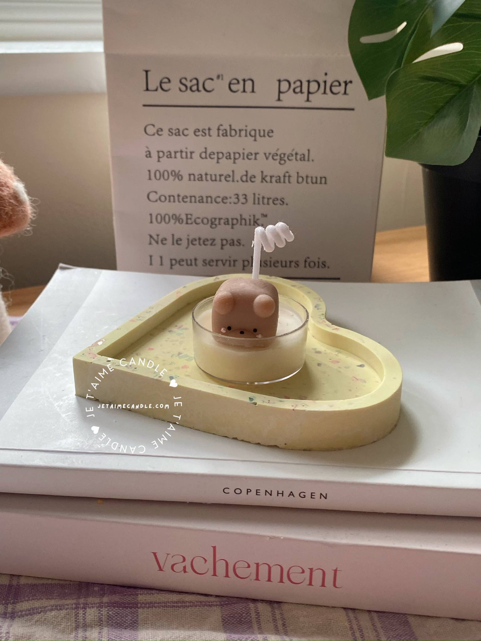 A table displaying unique animal-shaped candles and a book, perfect for enhancing the charm and coziness of any space.