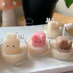 A table displaying unique animal-shaped candles and a book, perfect for enhancing the charm and coziness of any space.