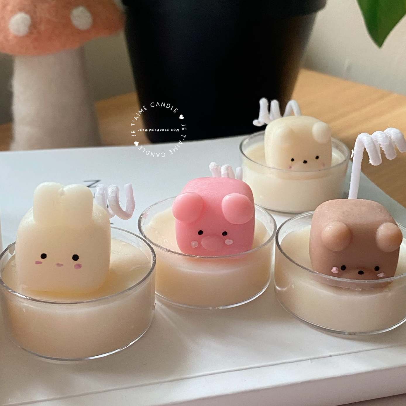A table displaying unique animal-shaped candles and a book, perfect for enhancing the charm and coziness of any space.