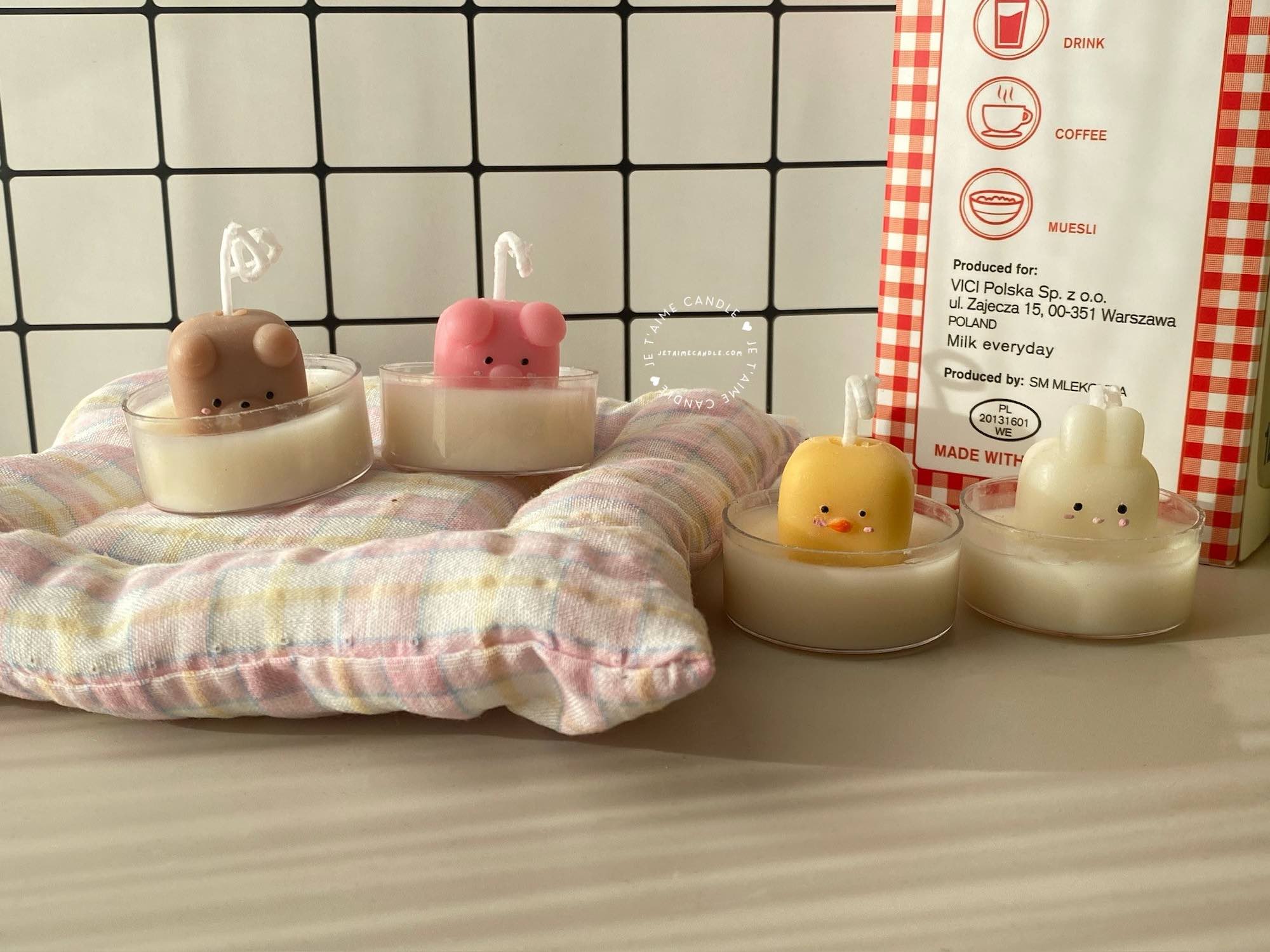 A table displaying unique animal-shaped candles and a book, perfect for enhancing the charm and coziness of any space.