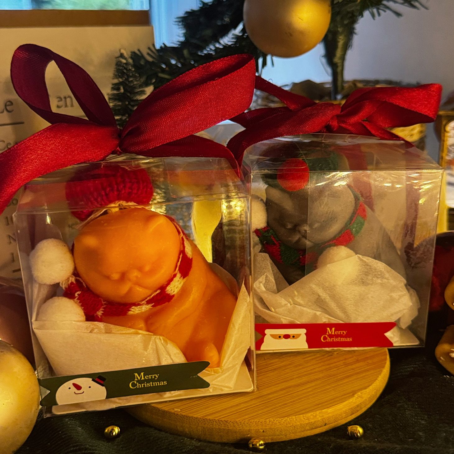 Two delightful toys in holiday-themed boxes, featuring Christmas decorations, including a Grumpy Cat Candle with a cozy hat.