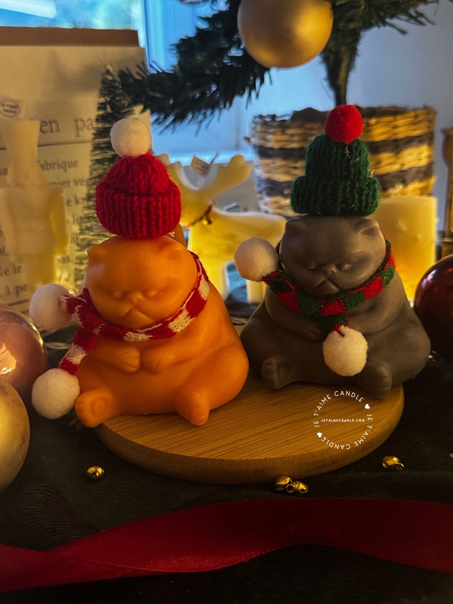 Two delightful toys in holiday-themed boxes, featuring Christmas decorations, including a Grumpy Cat Candle with a cozy hat.