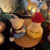 Two adorable teddy bears and bunny on a wooden tray, surrounded by festive Christmas decorations, radiating holiday cheer.