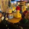 Two adorable teddy bears and bunny on a wooden tray, surrounded by festive Christmas decorations, radiating holiday cheer.