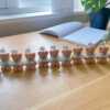 A delightful group of teddy bears on a table, showcasing the charm of our Handmade Mini Bear Candles in elegant bags.
