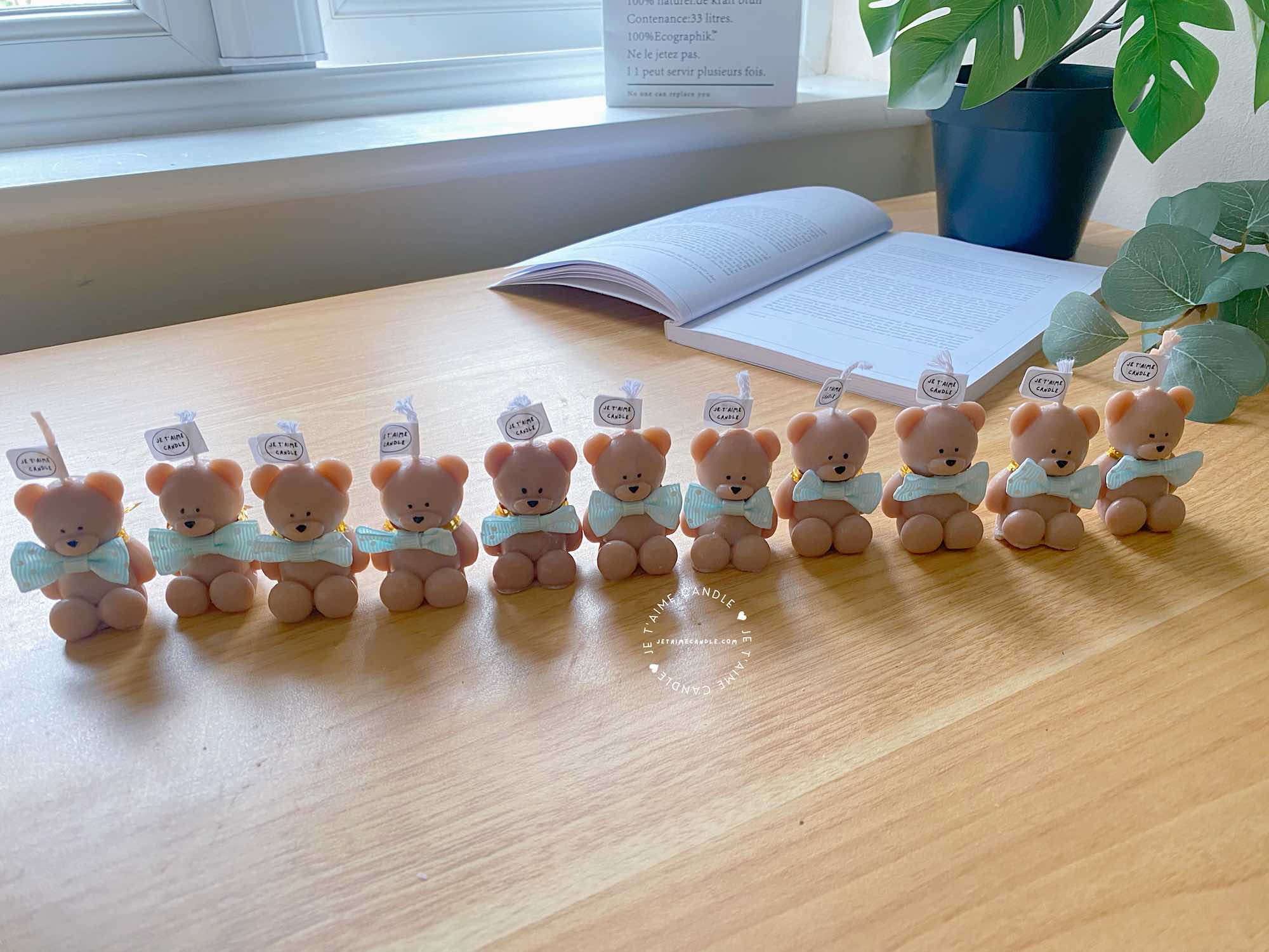 A delightful group of teddy bears on a table, showcasing the charm of our Handmade Mini Bear Candles in elegant bags.