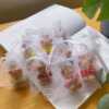 A delightful group of teddy bears on a table, showcasing the charm of our Handmade Mini Bear Candles in elegant bags.