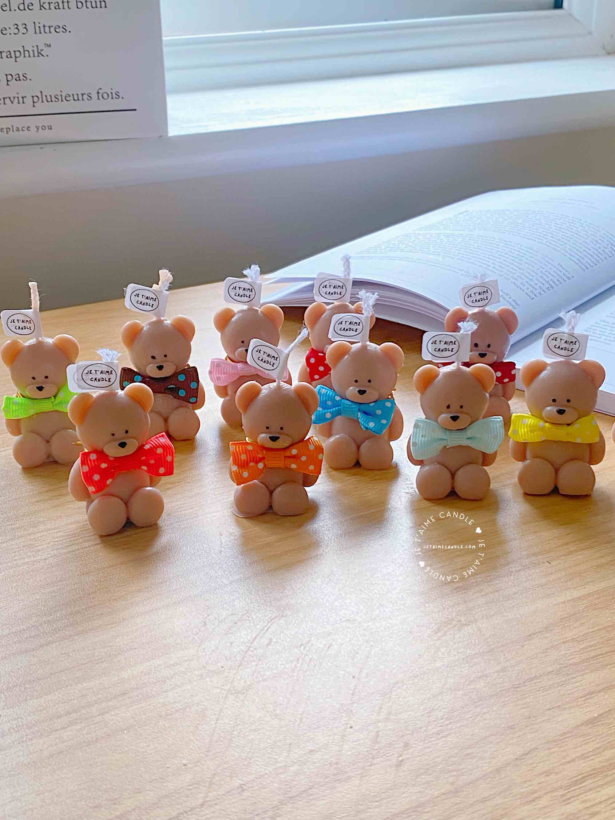 A delightful group of teddy bears on a table, showcasing the charm of our Handmade Mini Bear Candles in elegant bags.