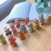 A delightful group of teddy bears on a table, showcasing the charm of our Handmade Mini Bear Candles in elegant bags.