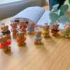 A delightful group of teddy bears on a table, showcasing the charm of our Handmade Mini Bear Candles in elegant bags.