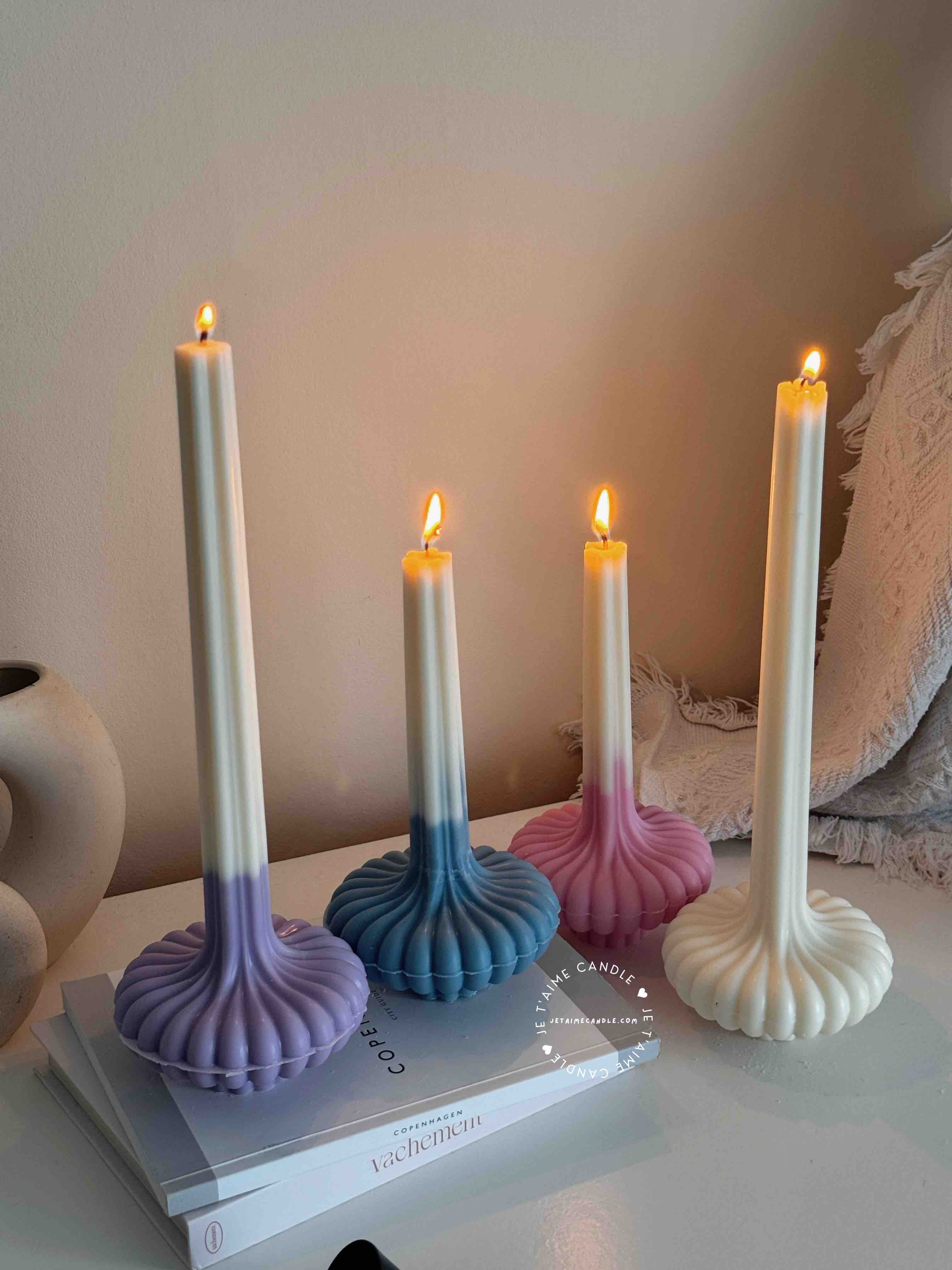 These are beautifully designed decorative candles with a unique aesthetic. The candles have an ombre effect that fades from a vibrant color at the bottom (pink, purple, and blue) to a creamy white at the top.