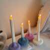 These are beautifully designed decorative candles with a unique aesthetic. The candles have an ombre effect that fades from a vibrant color at the bottom (pink, purple, and blue) to a creamy white at the top.