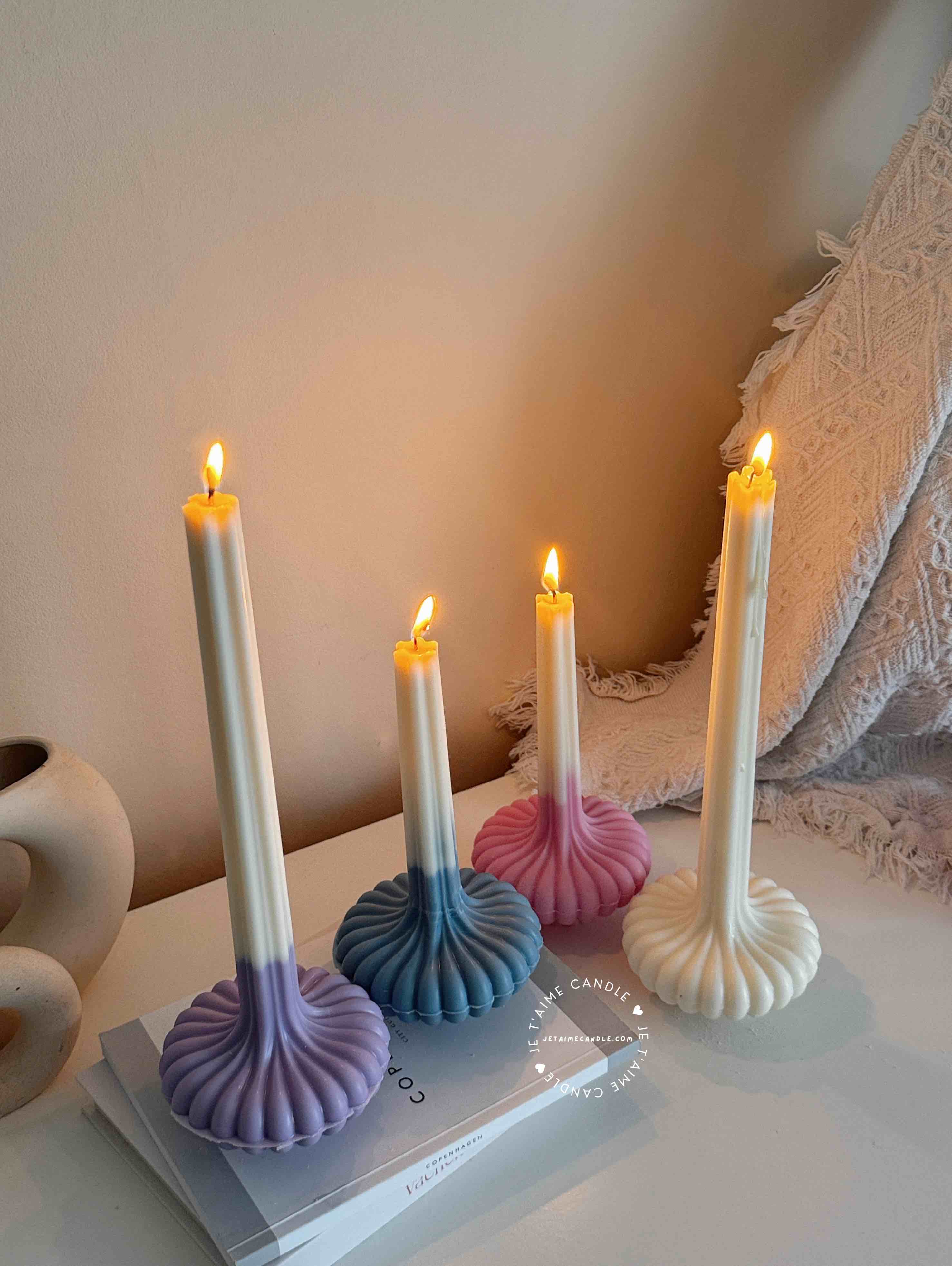 These are beautifully designed decorative candles with a unique aesthetic. The candles have an ombre effect that fades from a vibrant color at the bottom (pink, purple, and blue) to a creamy white at the top.