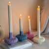 These are beautifully designed decorative candles with a unique aesthetic. The candles have an ombre effect that fades from a vibrant color at the bottom (pink, purple, and blue) to a creamy white at the top.