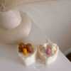 Two small cream white cakes topped with cute baby bear decorations and a colorful birthday candle.