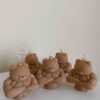 A delightful mix of small, colorful candles, showcasing the unique Buff Bear Candle, great for gifts and adding warmth to any space.