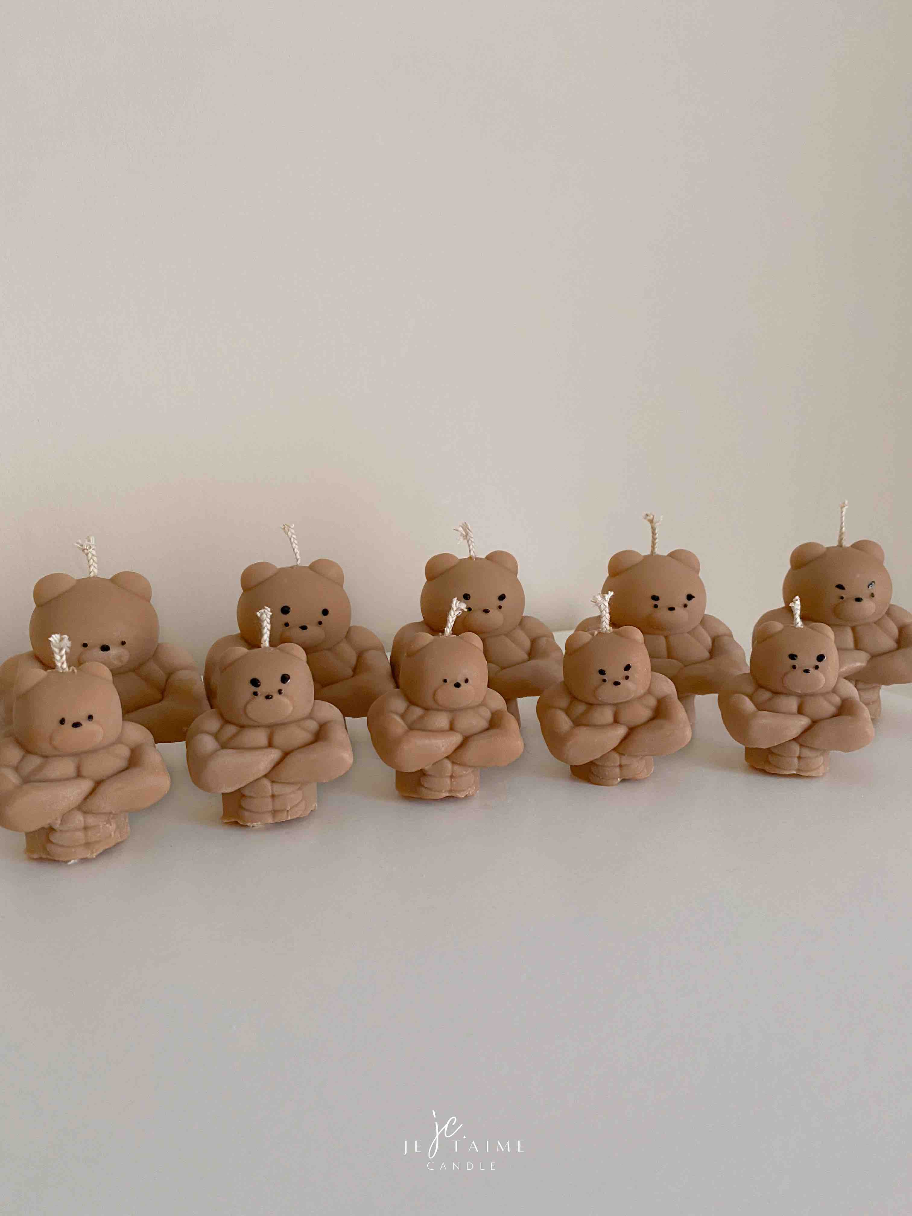 A delightful mix of small, colorful candles, showcasing the unique Buff Bear Candle, great for gifts and adding warmth to any space.