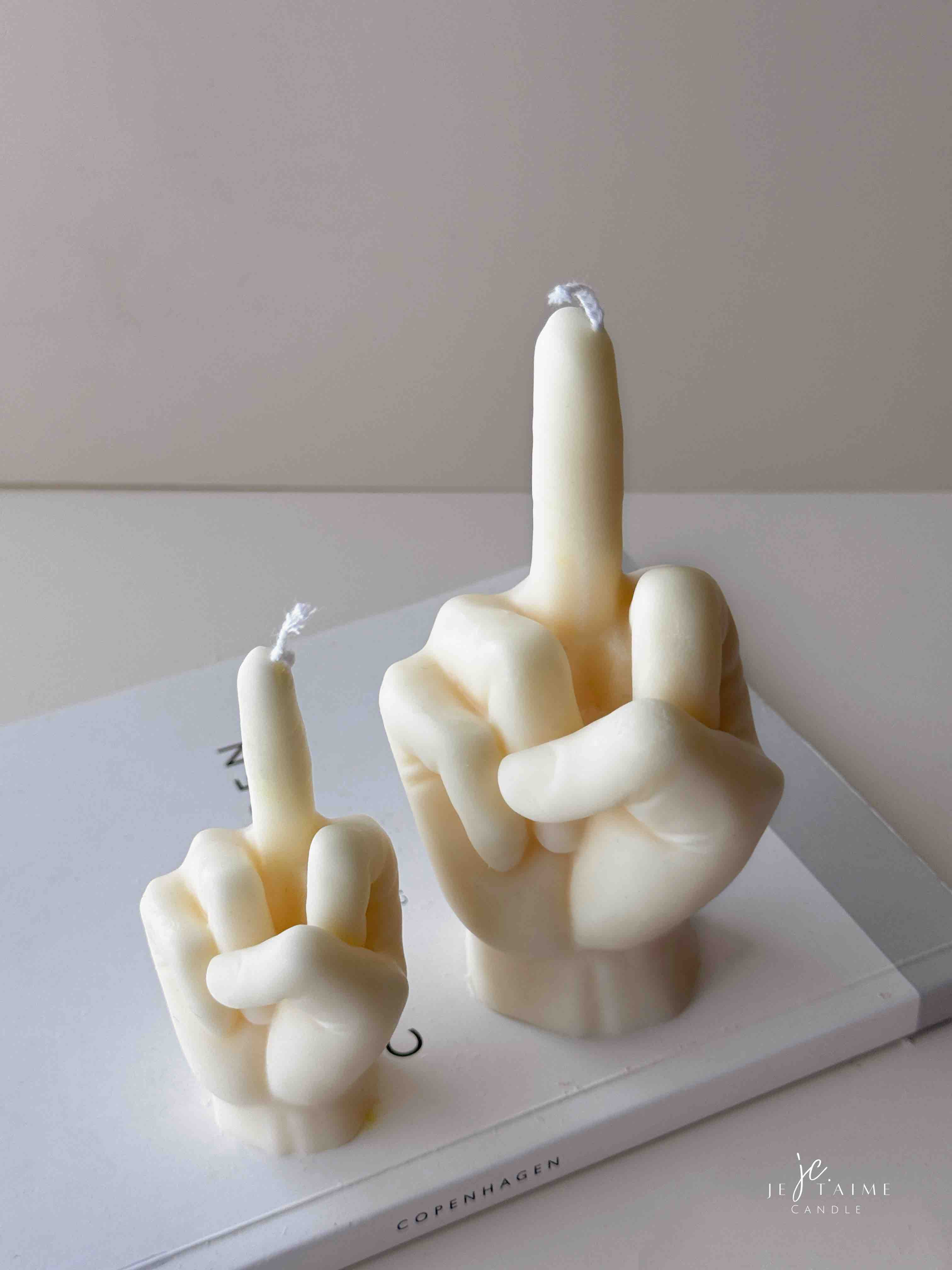 A row of multicolored candles shaped like hands making a gesture, lined up against a plain backdrop.