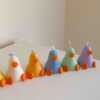 A row of cute, colorful duck candles lined up on a table, adding charm and whimsy to any space.