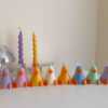 A row of cute, colorful duck candles lined up on a table, adding charm and whimsy to any space.