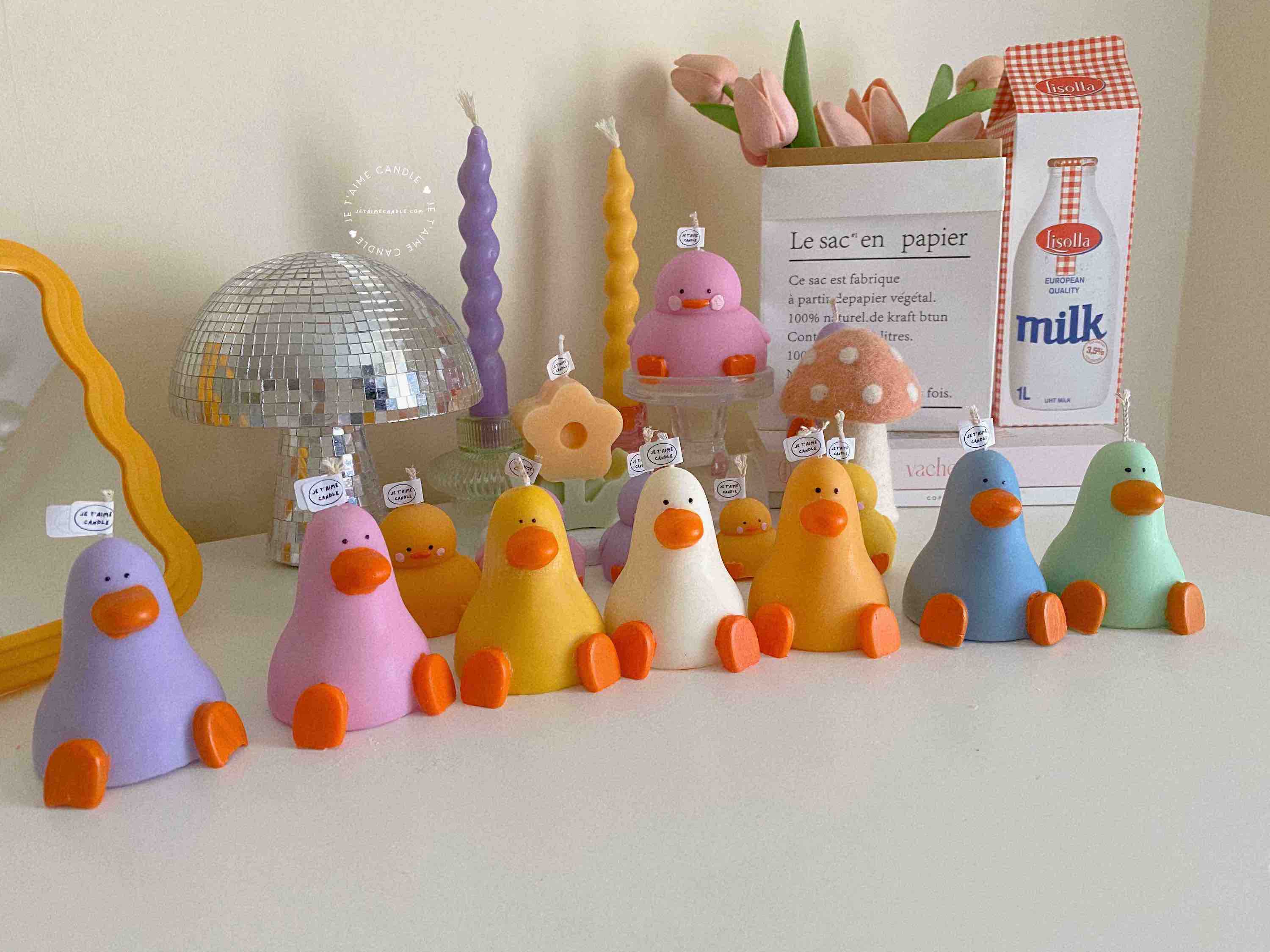 A row of cute, colorful duck candles lined up on a table, adding charm and whimsy to any space.