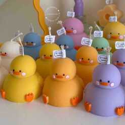 A collection of chubby duck-shaped candles on a table, perfect for duck lovers and quirky home decor enthusiasts.