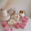 Two small cream white cakes topped with cute baby bear decorations and a colorful birthday candle.