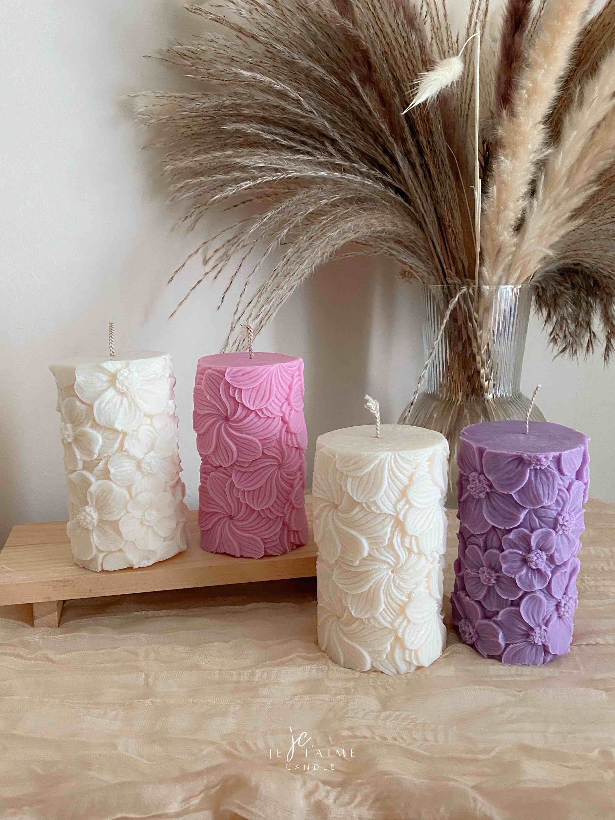 Four beautifully designed candles with floral and intricate patterns, adding elegance and warmth to any space.