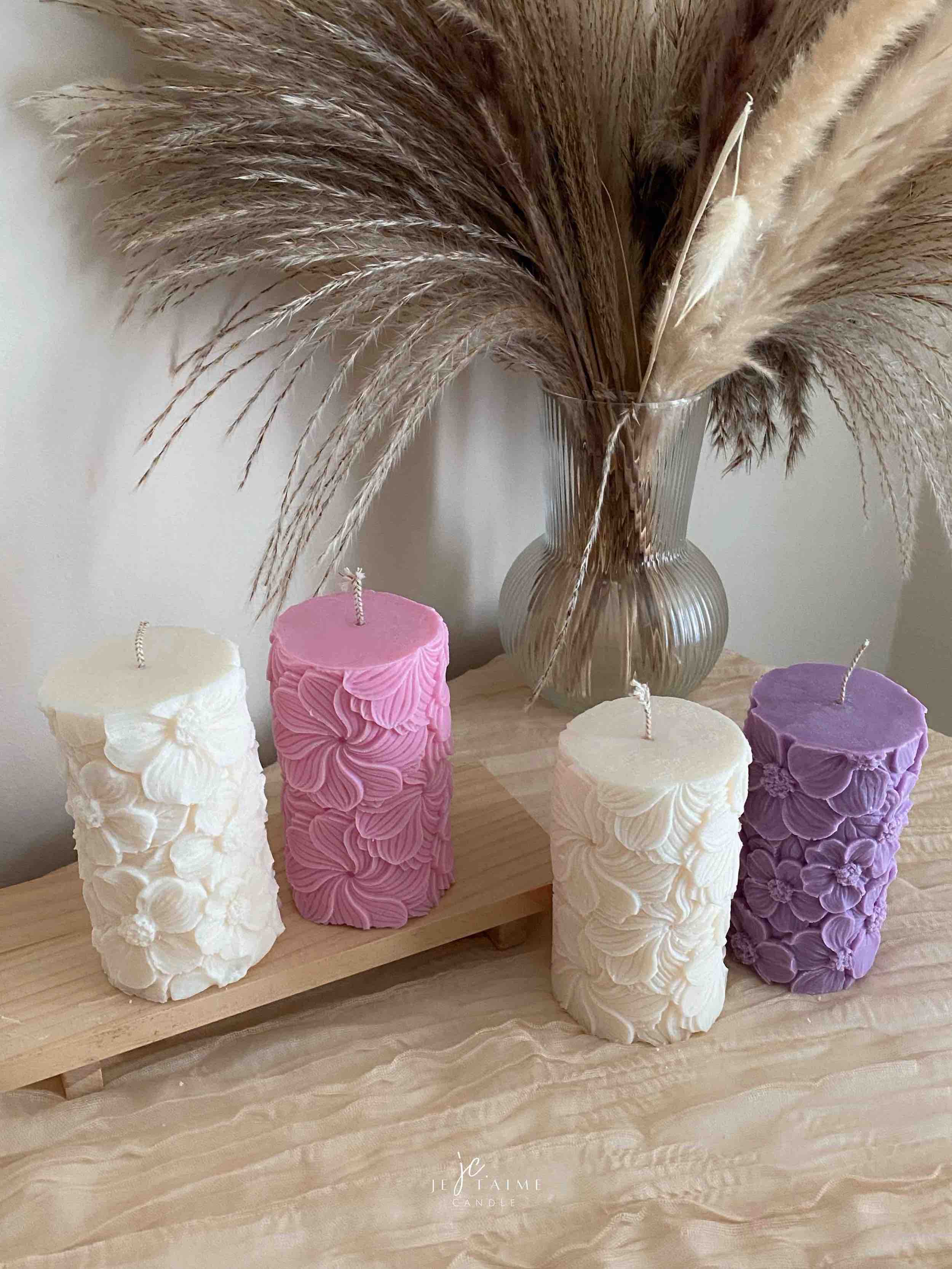 Four beautifully designed candles with floral and intricate patterns, adding elegance and warmth to any space.