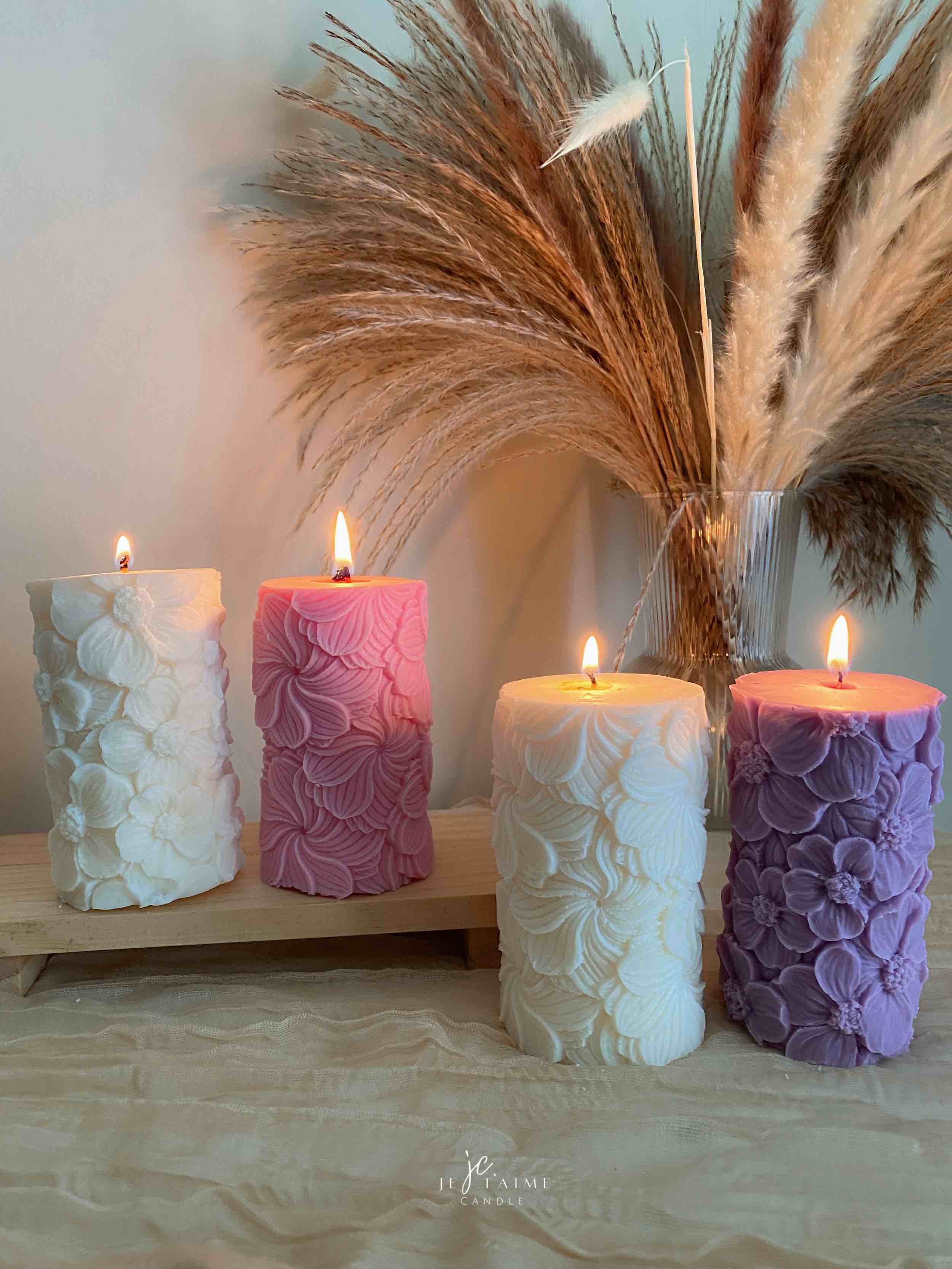 Four beautifully designed candles with floral and intricate patterns, adding elegance and warmth to any space.
