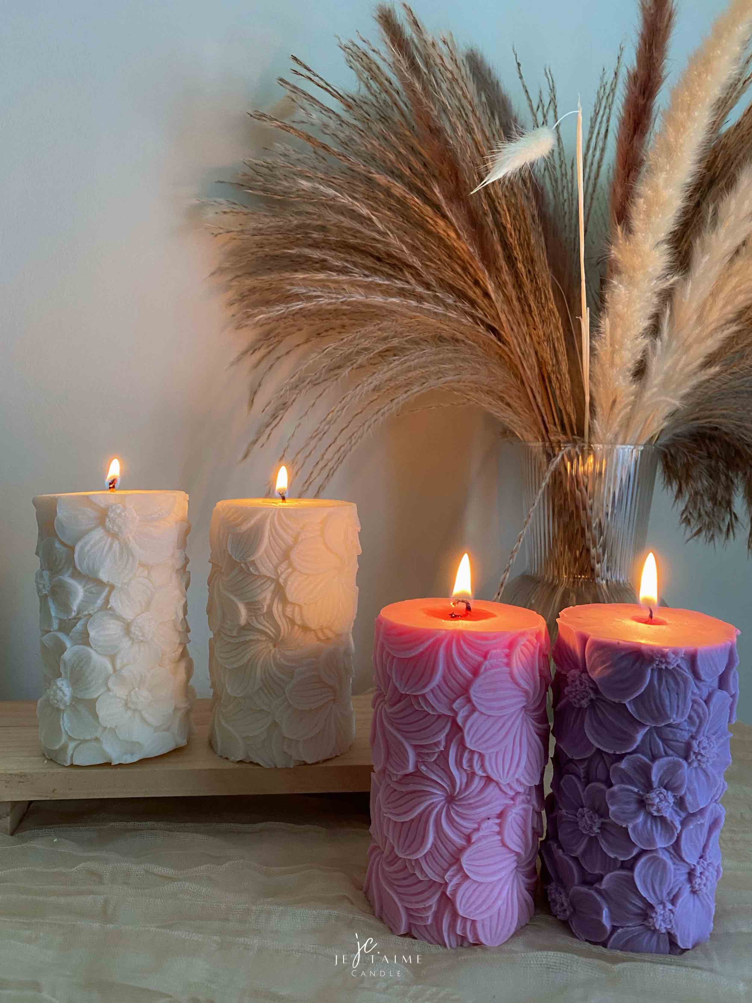 A tall handmade pillar candle featuring a delicate floral embossed pattern, crafted from soy wax in an elegant design. The candle stands upright on a neutral-toned background, highlighting its textured botanical details. Perfect as a decorative candle for weddings, home décor, or special occasions, this floral relief pillar candle adds sophistication, warmth, and charm to any setting. Ideal as a gift for candle lovers, rustic décor accent, or centerpiece decoration.