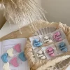 This image showcases beautifully packaged baby shower favors in the shape of small baby feet, made of wax. The favors come in pastel colors, including pink, blue, and white, and are individually wrapped in clear plastic with a 