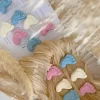 This image showcases beautifully packaged baby shower favors in the shape of small baby feet, made of wax. The favors come in pastel colors, including pink, blue, and white, and are individually wrapped in clear plastic with a 